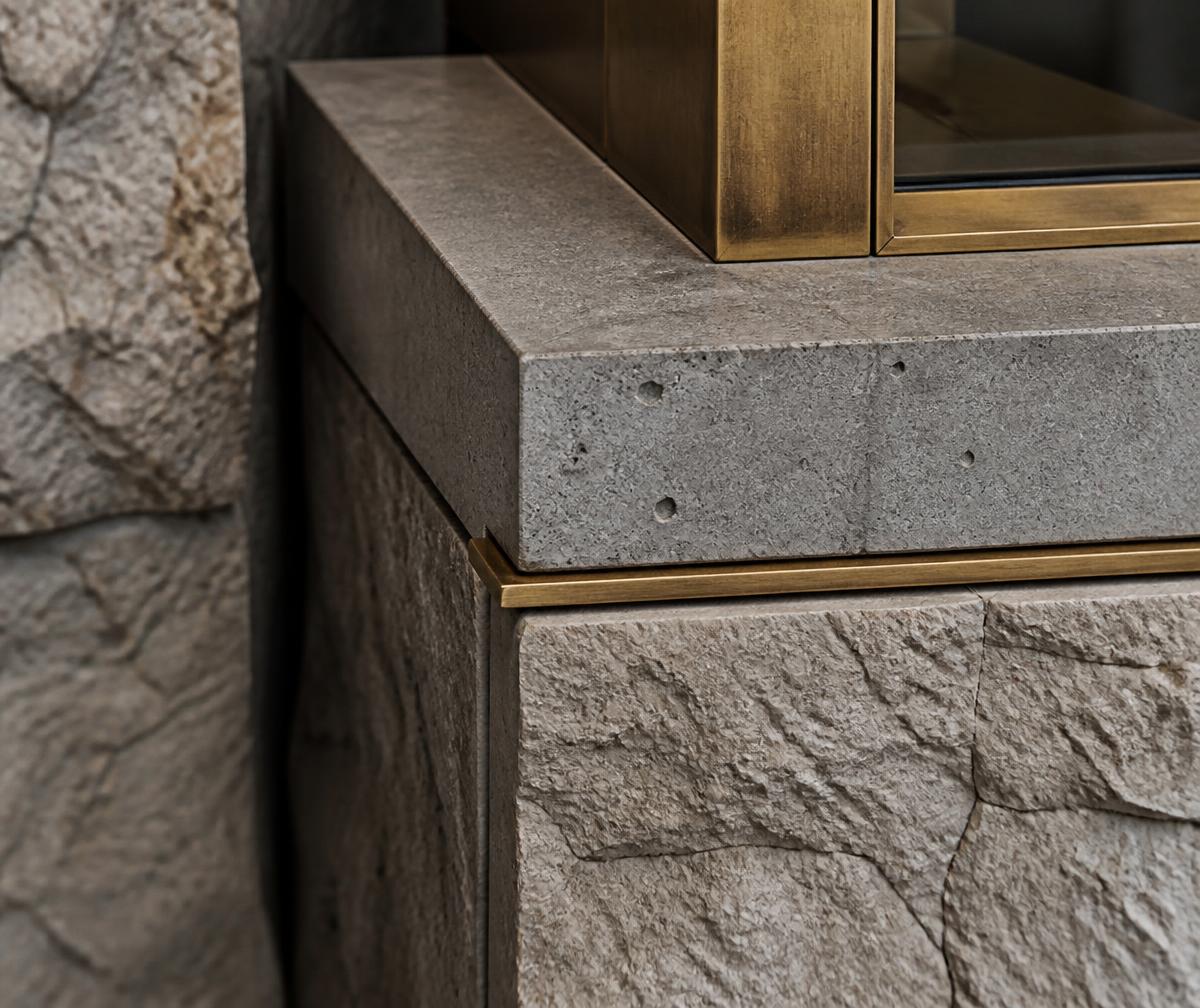 Detalhe construtivo de acabamento premium em pedra e latão